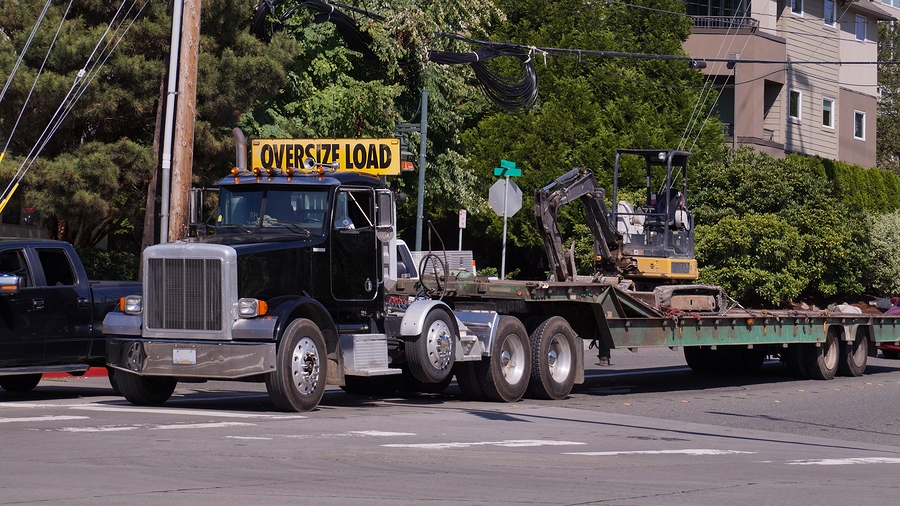 A truck with a wide semi-trailer for hauling oversized loads.